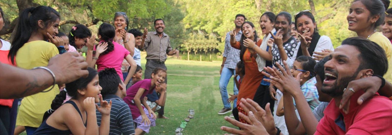 Children and volunteers laughing together outdoors