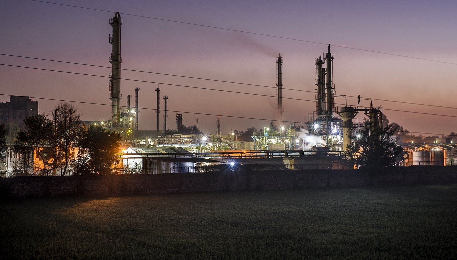 A chemical plant lit up at dusk